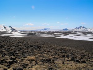 Lava field and mountain peaks on Iceland covered in snow